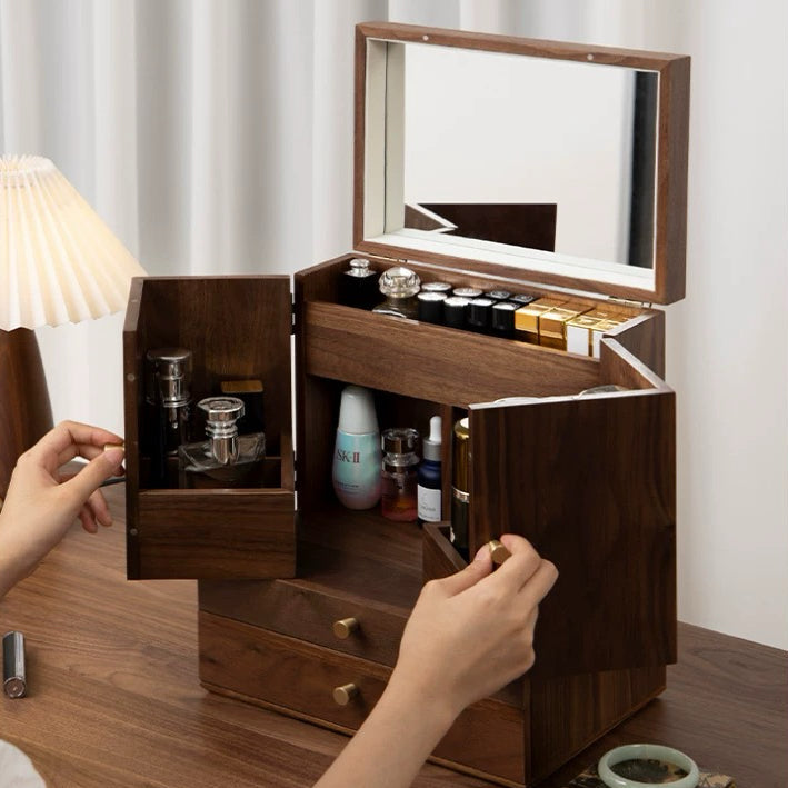 Wooden jewelry box with mirror and compartments on a wooden surface.