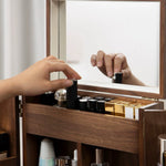 Wooden vanity with makeup products and a hand reaching for a bottle.