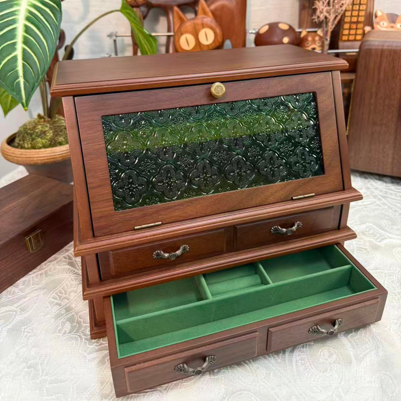 Wooden jewelry box with green interior on a light background